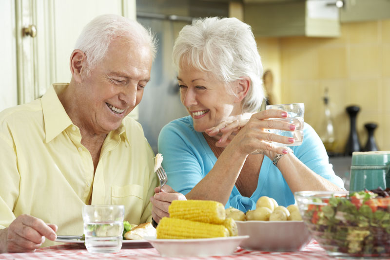 Dental Implant Patients Eating Dinner Together And Smiling