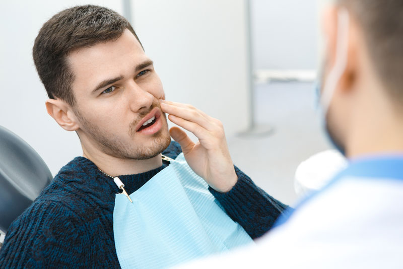 Dental Patient Suffering From Mouth Pain On A Dental Chair, In Albuquerque, NM