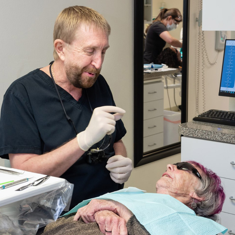 Dr Craig T Steichen Talking To A Patient Laying In A Dental Chair